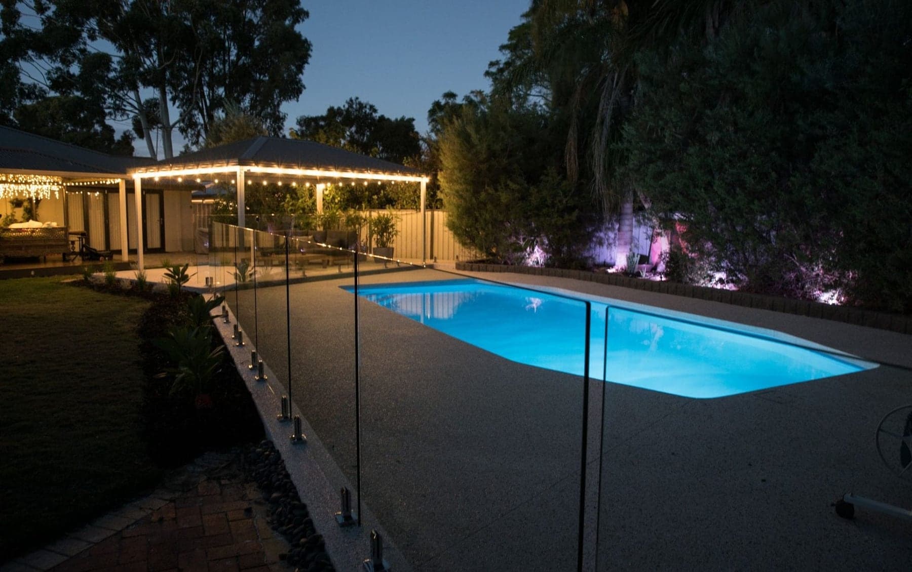 Concrete pool surround and seamless edge at night